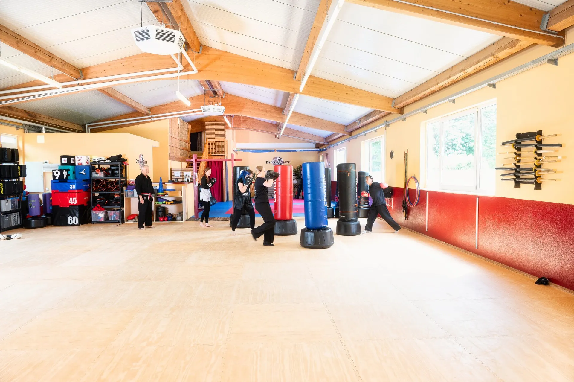 Trainingshalle der Kampfsportschule Neufahrn mit Boxsäcken und Waffenständer